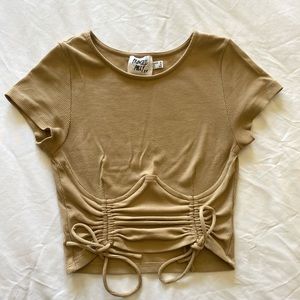 tan short sleeve top, cropped. cinched sides are adjustable.